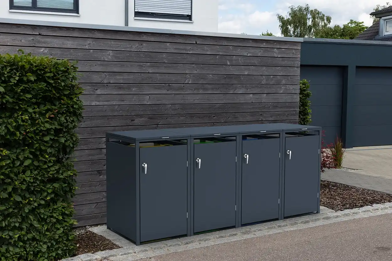 Mülltonnenbox für vier Tonnen mit geschlossenem Design in modernem Anthrazitgrau, passend zur Hauswand und Gartenumgebung.